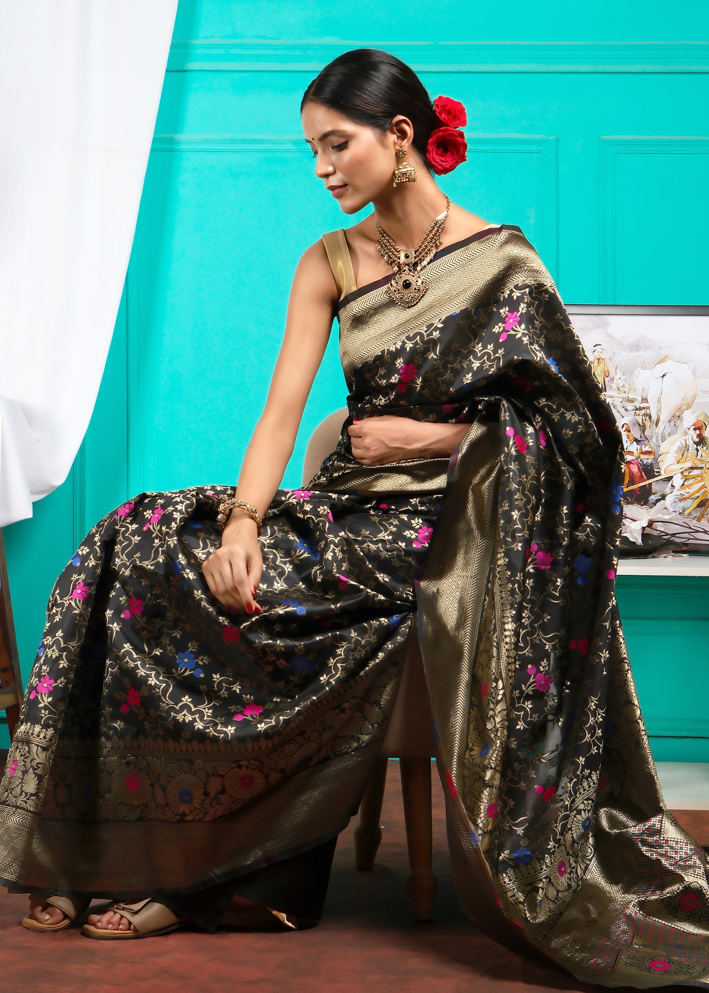 Side view of a model wearing a black Banarasi saree, highlighting the rich gold zari border and floral accents