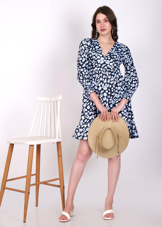 Model posing in a trendy navy blue dress with white abstract prints, holding a wide-brimmed hat, ideal for casual and vacation wear