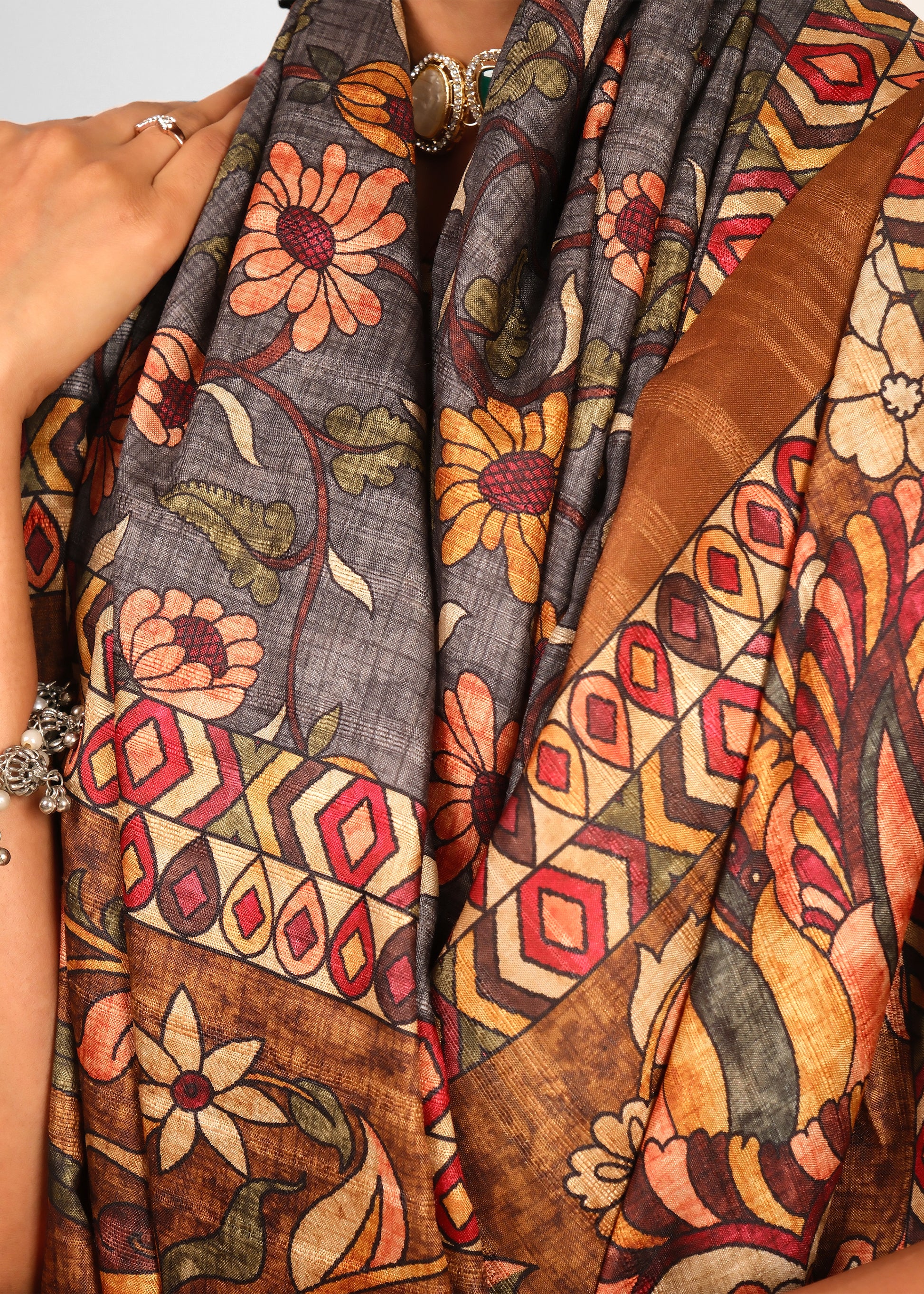 Close-up view of floral saree fabric with detailed patterns and colorful designs