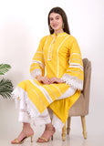 Model seated wearing a yellow embroidered kurta with lace detailing on the sleeves and hem, paired with white straight pants and beige strappy sandals, styled for an elegant day look