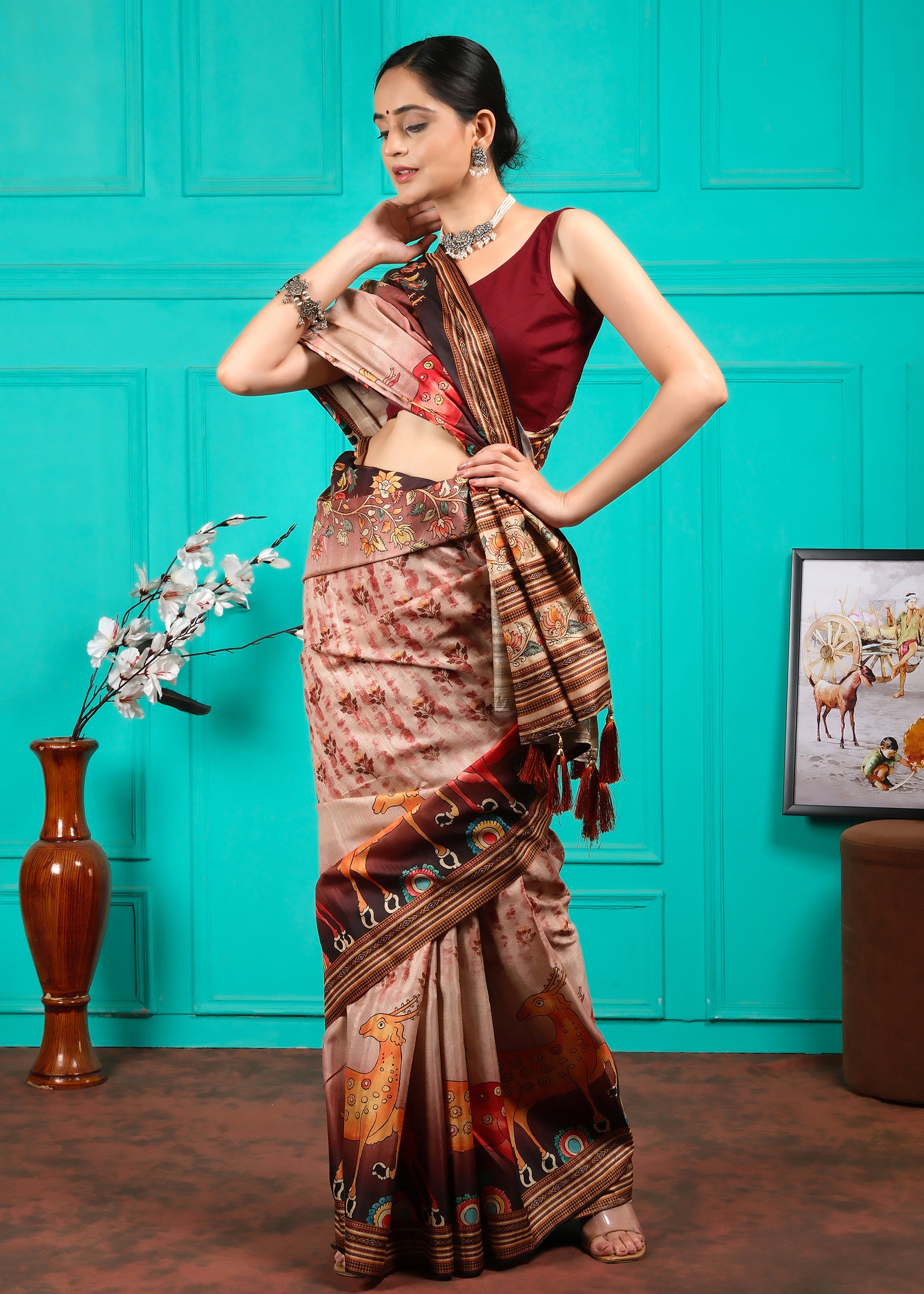 Beige saree with animal and floral designs, styled with traditional silver jewelry