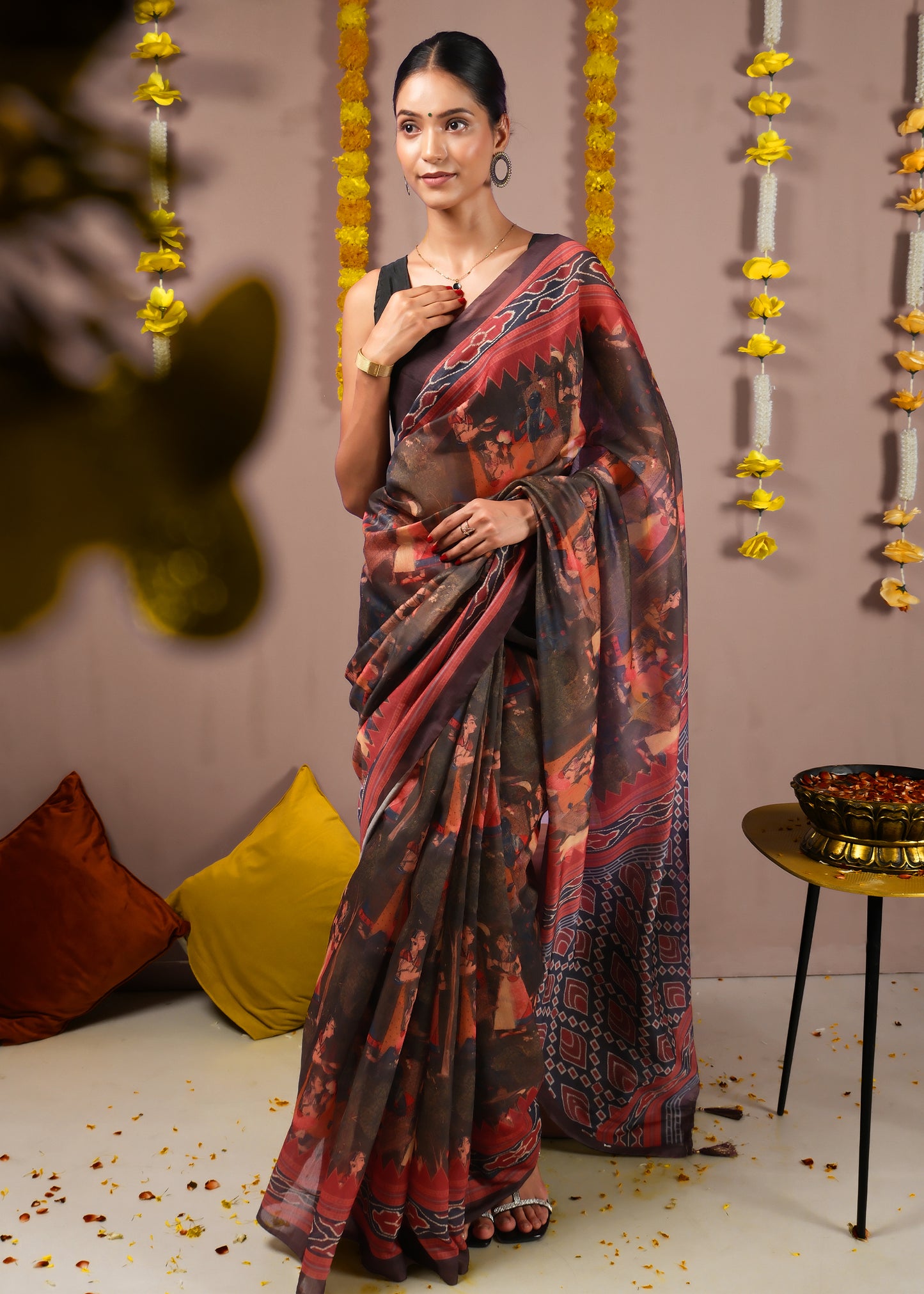 Woman elegantly posing in a red and black saree, designed with intricate geometric and cultural motifs, perfect for weddings and cultural celebrations.