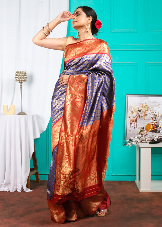 Elegant lady in a Banarasi silk saree, styled in royal blue and red with intricate golden motifs, perfect for traditional events and weddings