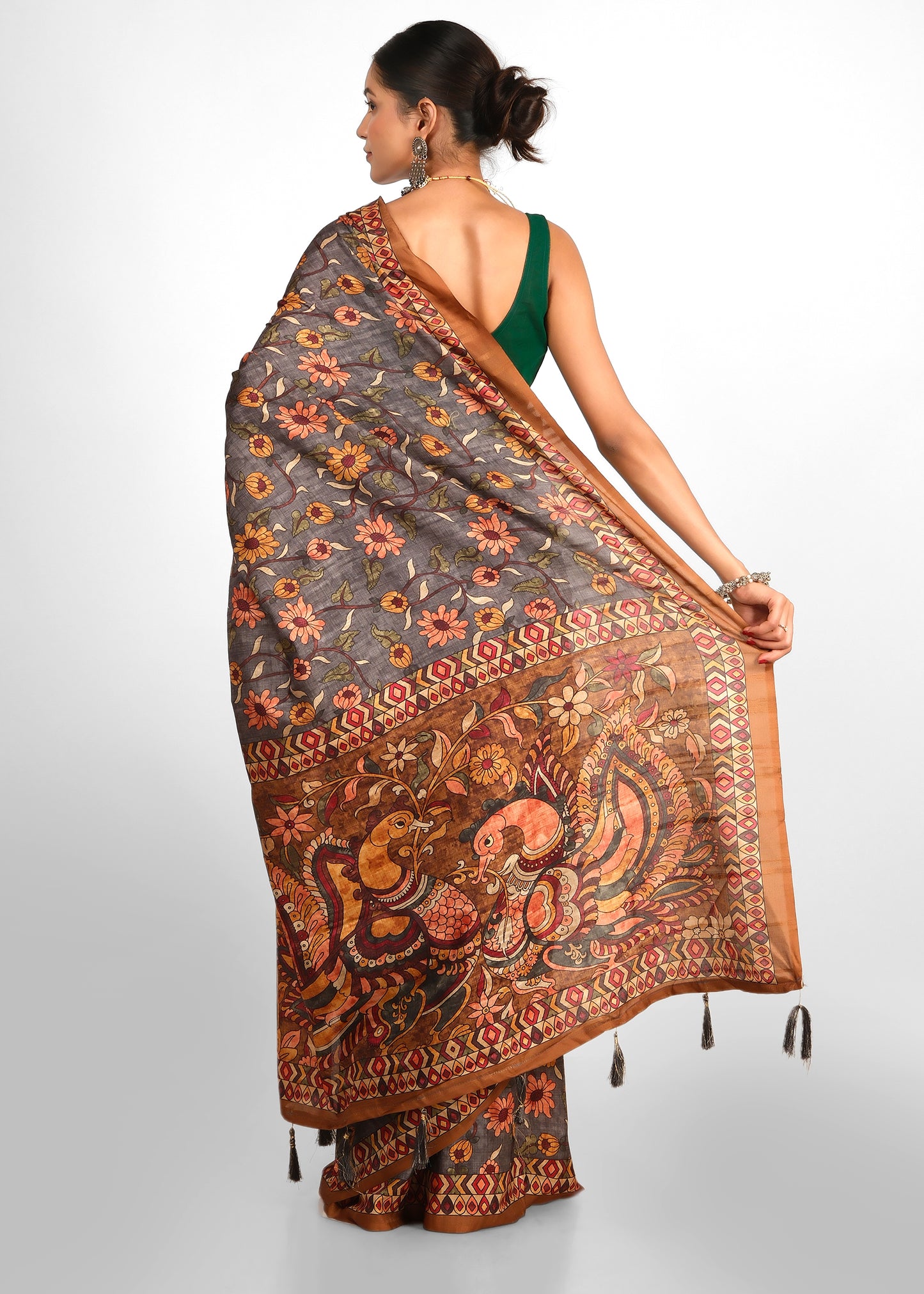 Model displaying the reverse side of a saree with an elaborate embroidered pallu featuring traditional motifs